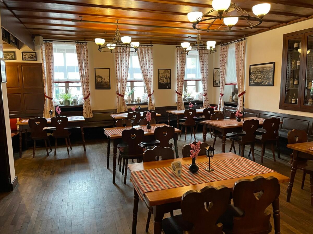 Gastraum im Zieglerbräu Friedberg mit dunklem Holz und gedeckten Tischen.